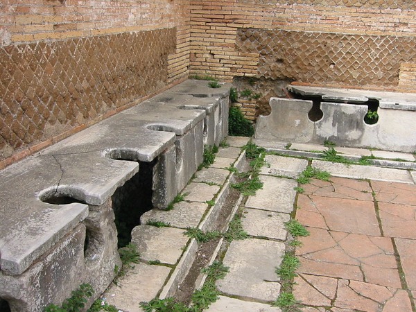 Römische Latrinen waren wortwörtlich ein öffentlicher Ort. Hier ein Foto vom Ausgrabungsort Ostia Antica. Römische Latrine